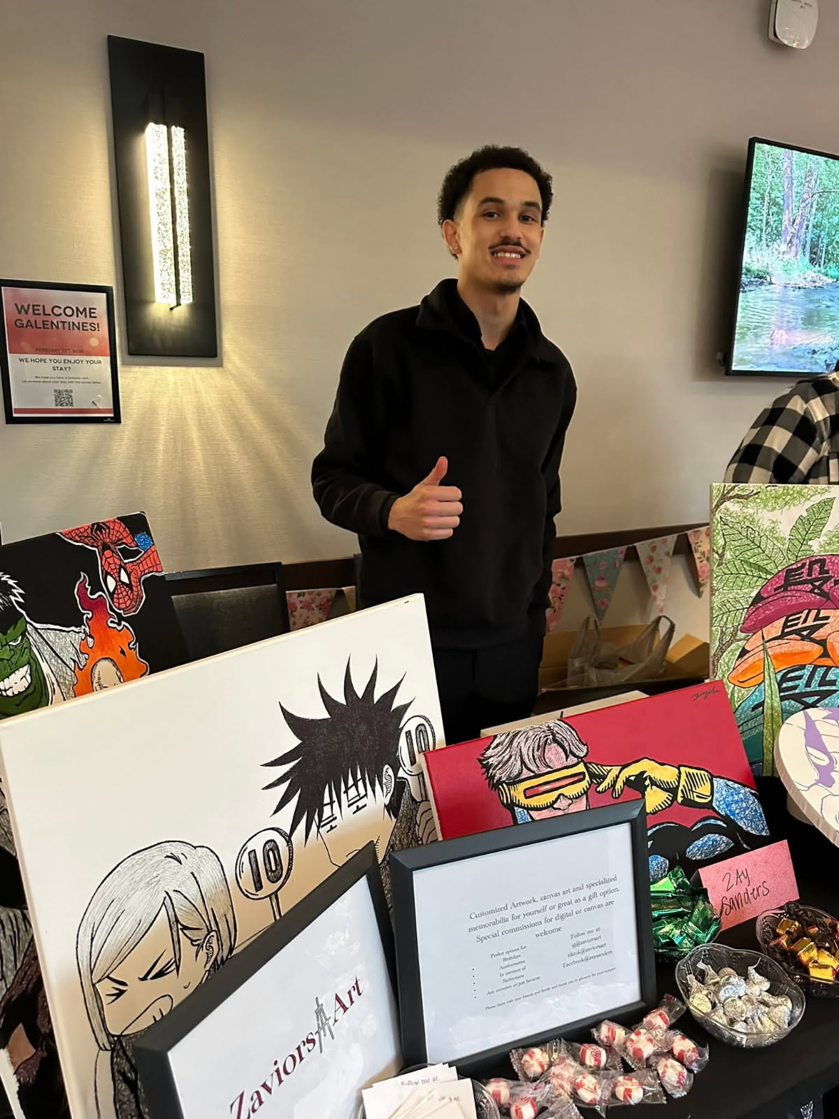 Zay Sanders at an art event with his canvas works